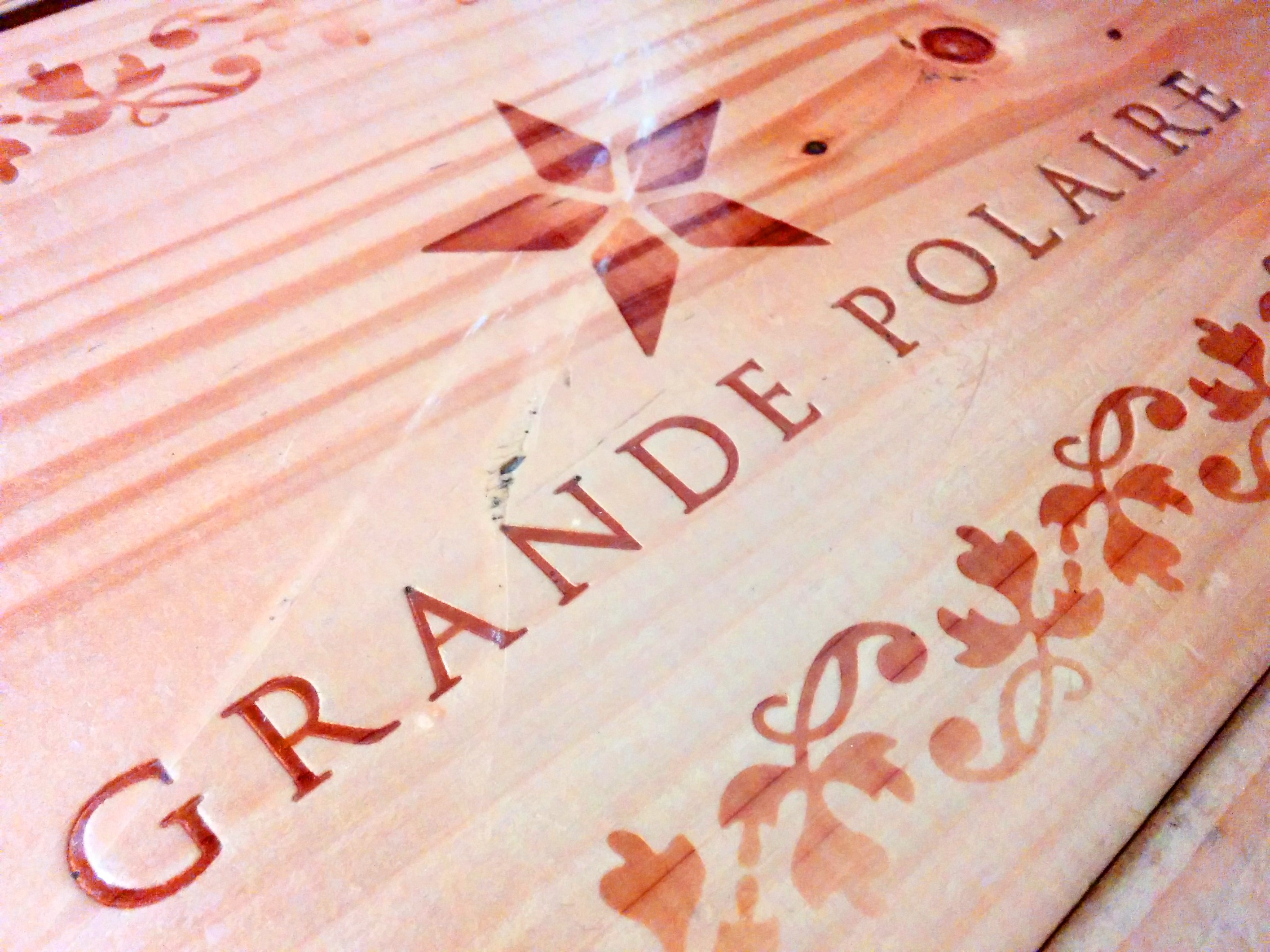 木のテーブルに、 GRANDE POLAIRE という文字が焼き込まれています。